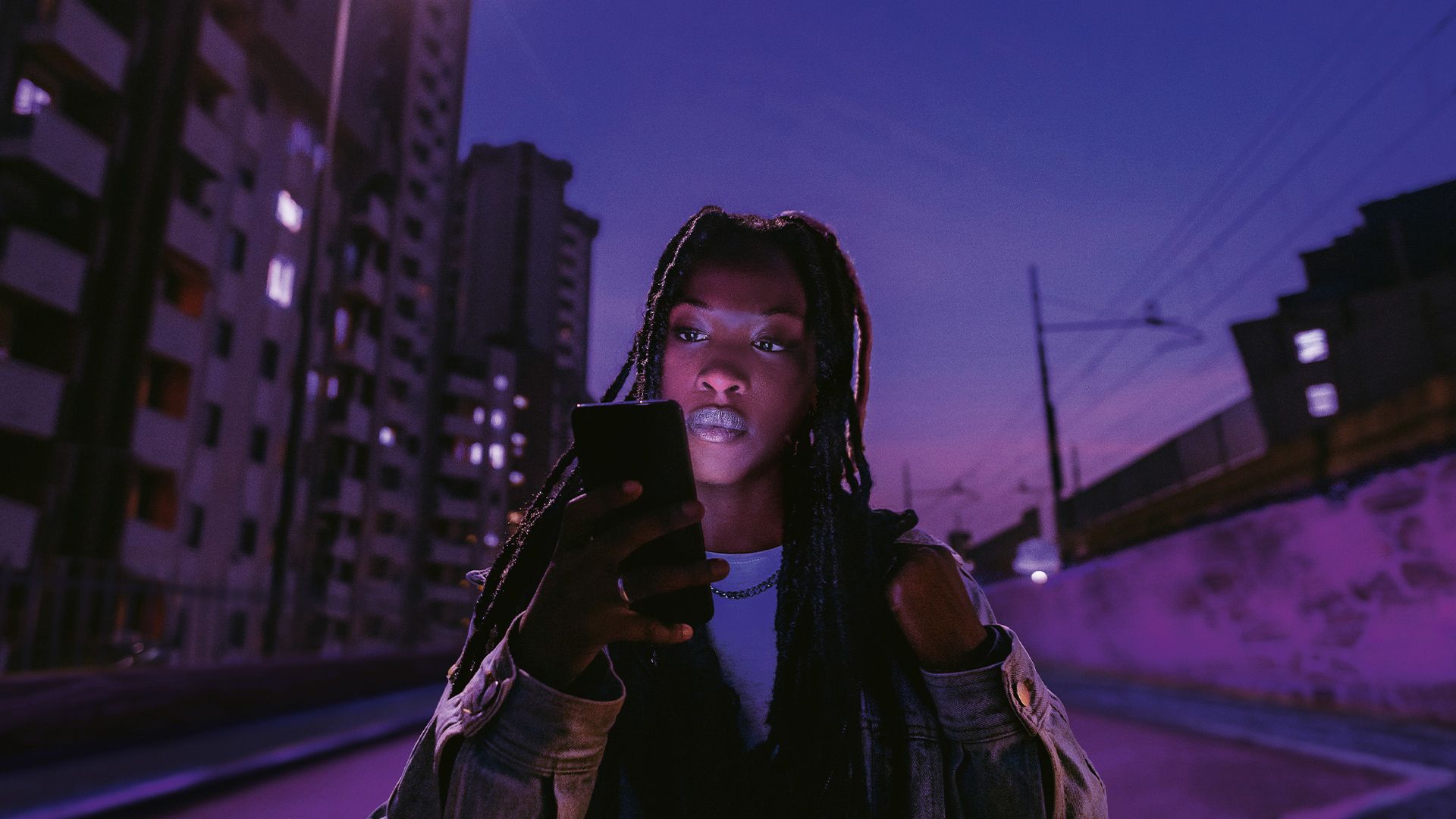 Frau blickt auf ihr Smartphone, das sie in der Hand hält.