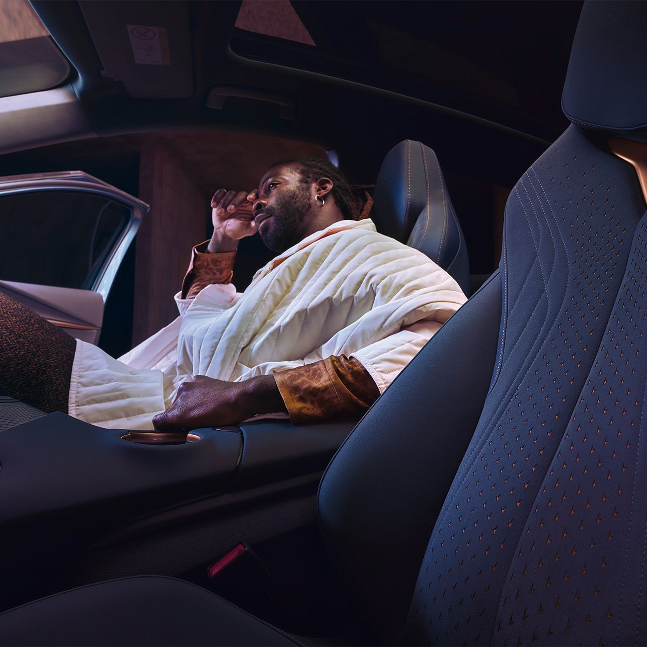 Innenansicht eines CUPRA Tavascan, ein Mann sitzt auf dem Beifahrersitz.