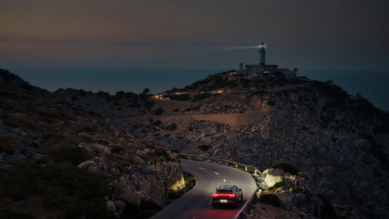 Ein CUPRA Formentor bei Nacht auf einer gebirgigen Küstenstraße