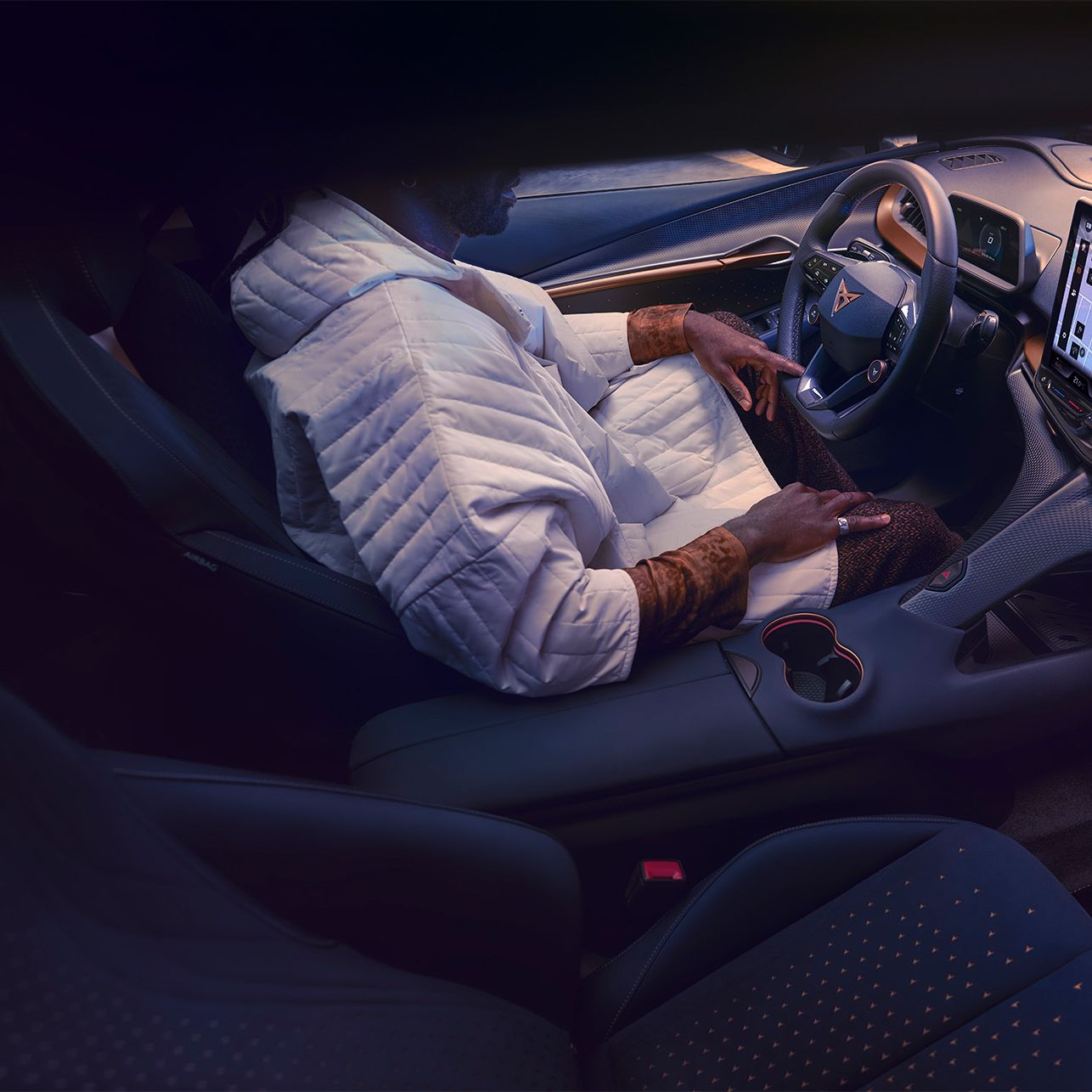 Ein Mann sitzt am Fahrersitz eines CUPRA Tavascan.