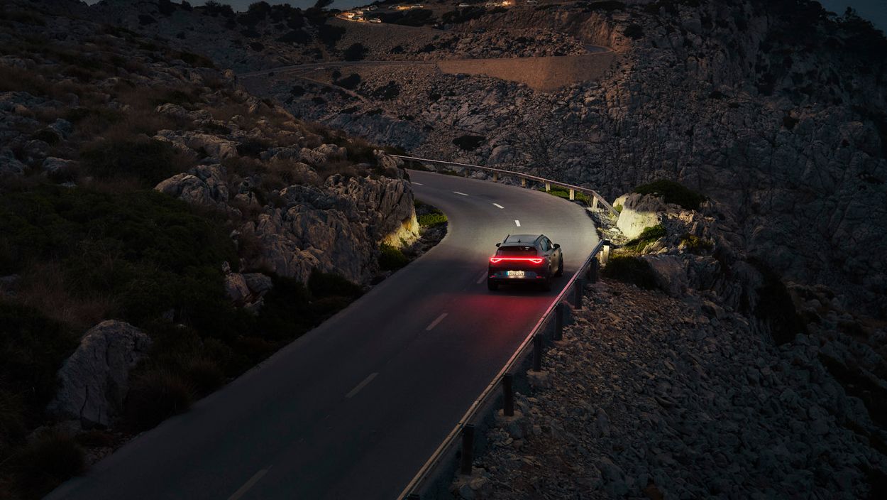 Ein CUPRA Formentor bei Nacht auf einer gebirgigen Küstenstraße